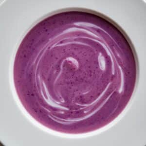 Création d'une photo pesant MAXIMUM 300ko d'un plat vu du haut dressé dans une assiette du plat velouté au chou rouge de couleur mauve clair de façon réaliste