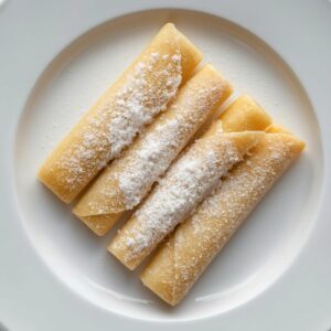 Création d'une photo pesant maximum 300ko format carrée 1 1 d'un plat vu du haut dressé dans une assiette du plat « 3 crêpes natures roulées avec du sucre blanc de façon réaliste