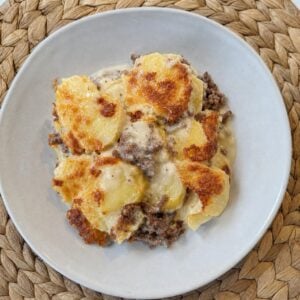 Création d'une photo (Format d'image jpg png; Taille de l'image = 500 Ko; taille 560 800). d'un plat vu du haut dressé dans une assiette du plat gratin de pomme de terre avec viande hachée et crè