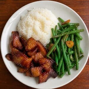 Création d'une photo (Format d'image jpg png; Taille de l'image = 500 Ko; taille 560 800). d'un plat vu du haut dressé dans une assiette du plat porc au caramel, haricot sauté à l'ail et riz de