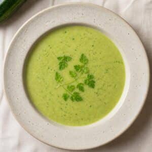 Création d'une photo (Format d'image jpg png; Taille de l'image = 500 Ko; taille 560 800). d'un plat vu du haut dressé dans une assiette du plat soupe courgette cerfeuil de façon réaliste