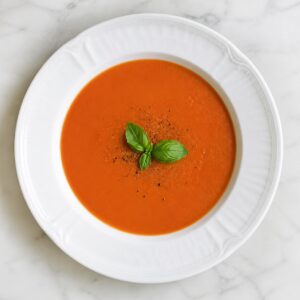 Création d'une photo (Format d'image jpg png; Taille de l'image = 500 Ko; taille 560 800). d'un plat vu du haut dressé dans une assiette du plat velouté à la tomate de façon réaliste (1)