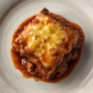 Création d'une photo pesant MAXIMUM 300ko d'un plat vu du haut dressé dans une assiette du plat moussaka de façon réaliste