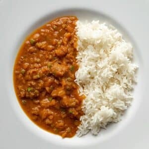 Création d'une photo pesant maximum 300ko format carrée 1 1 d'un plat vu du haut dressé dans une assiette du plat «dhal de lentille corail avec riz de façon réaliste