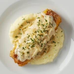 Création d'une photo pesant maximum 300ko format carrée 1 1 d'un plat vu du haut dressé dans une assiette du plat «roulade d'endive à la sauce blanche, gratinée au fromage accompagné de purée de pomme de